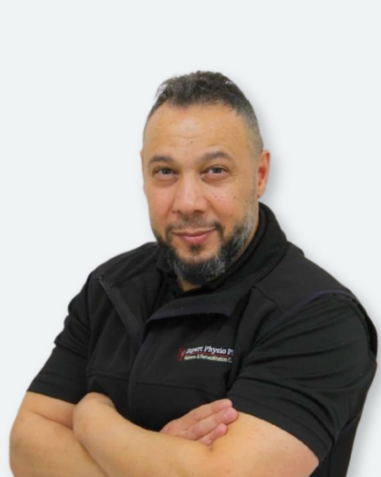 Portrait of a man with beard wearing a black polo shirt with arms crossed against a white background