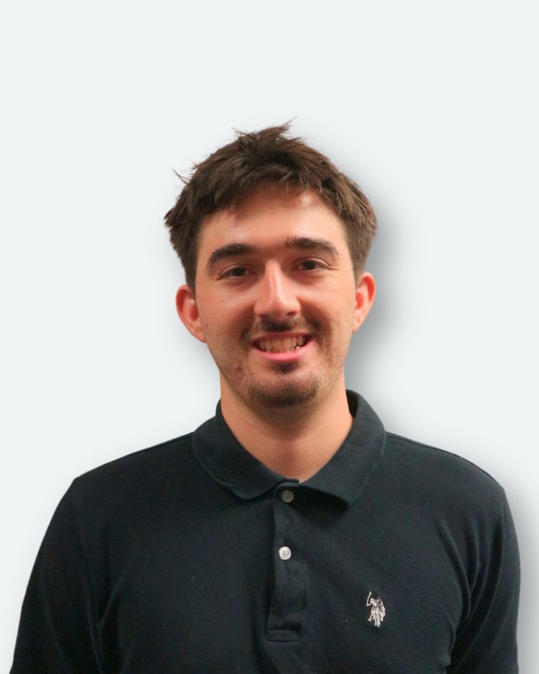 Smiling man with brown hair wearing a dark polo shirt against a white background