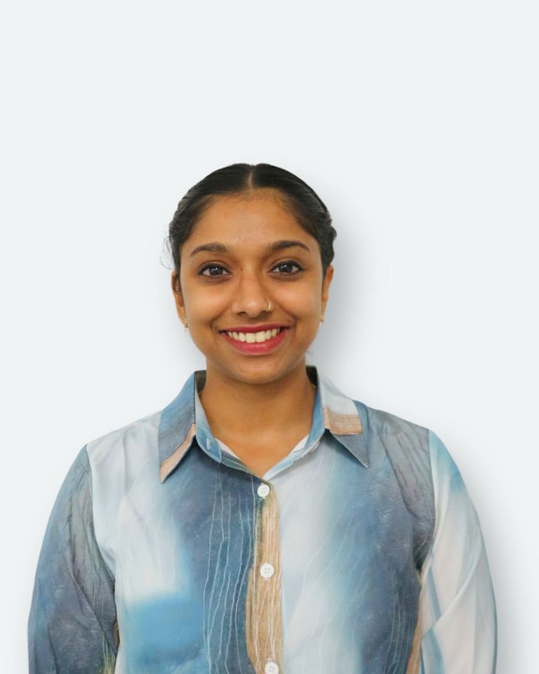 Portrait of a smiling woman wearing a light blue denim shirt against a white background