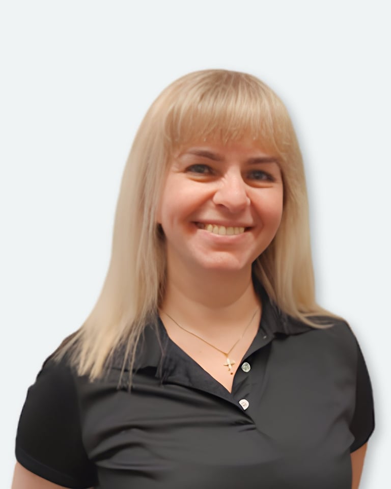 Smiling woman with blonde hair and bangs wearing a black polo shirt against a white background