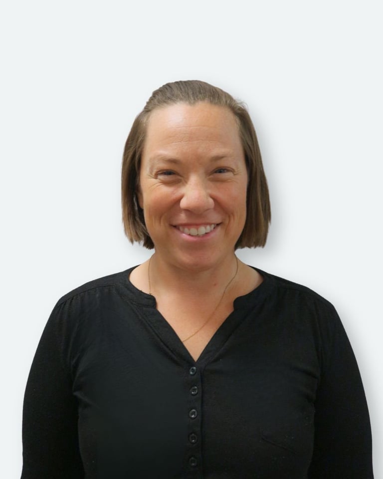 Woman with shoulder-length brown hair wearing a black button-up shirt, smiling at the camera against a white background