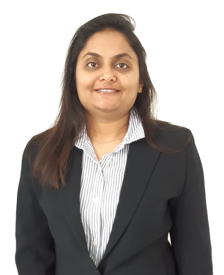 Professional headshot of a woman wearing a black blazer and white striped shirt, smiling at the camera against a white background.