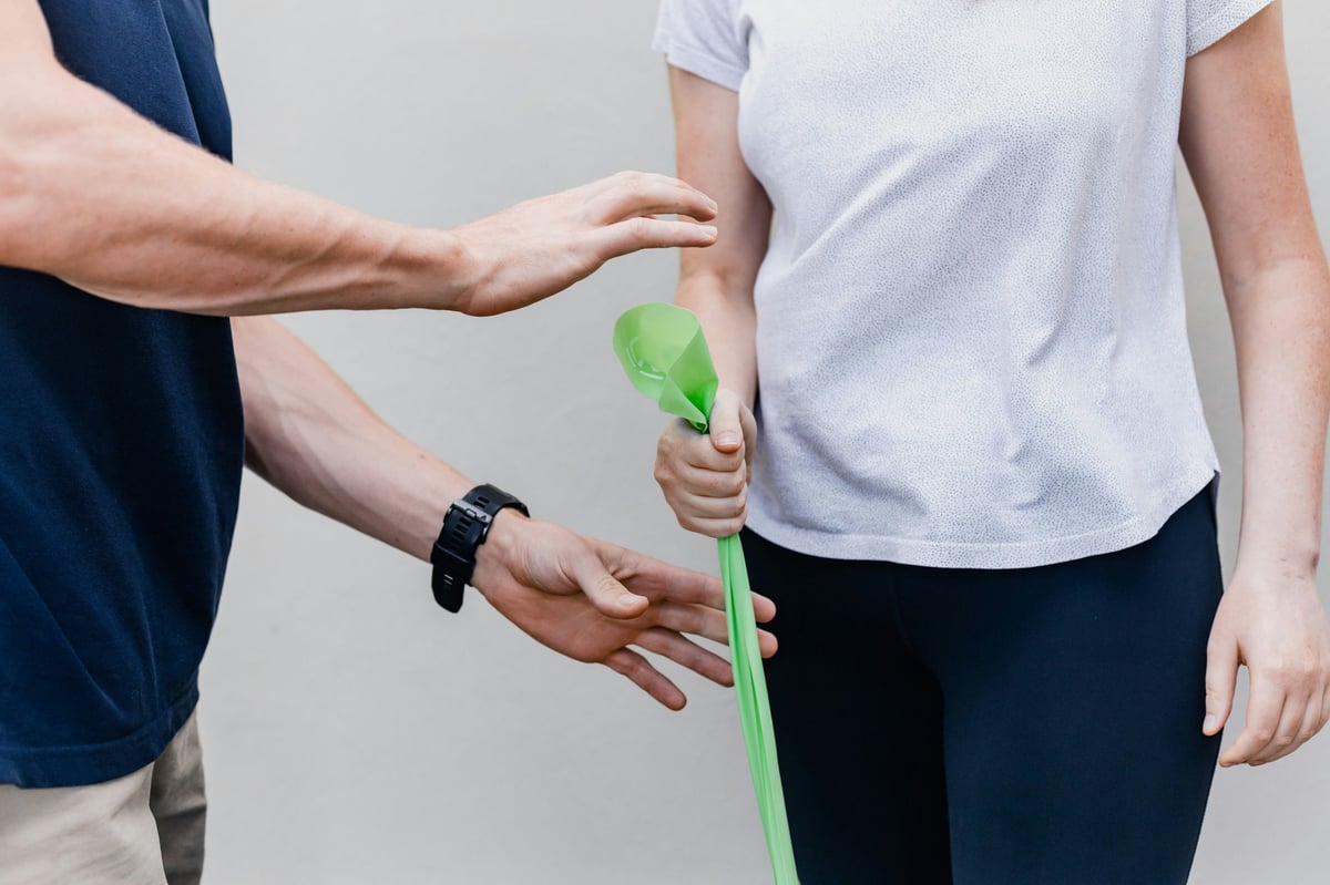 Two people exchanging a green recycling symbol or eco-friendly token between their hands.