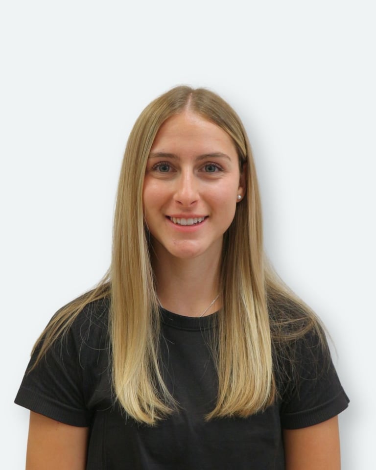 Young woman with long blonde hair wearing a black t-shirt, smiling at camera against white background